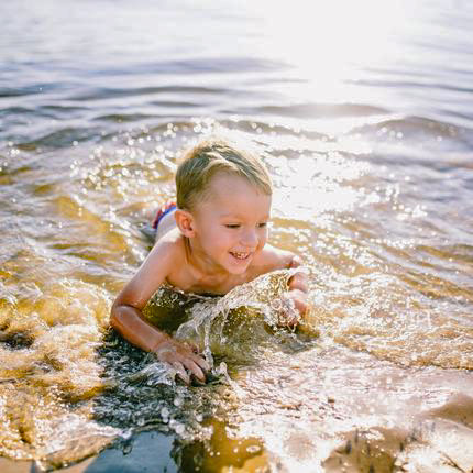 Baignade d'un petit garçon dans l'étang au camping l'étang du merle