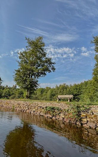 Banc en bois au bord de l'eau au camping l'étang du merle