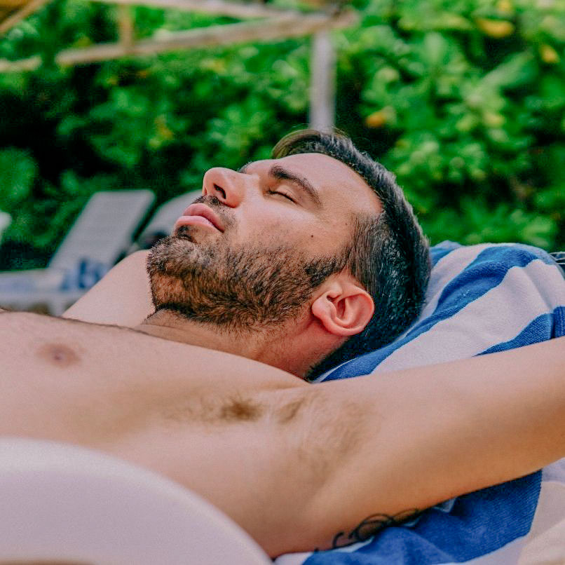 Homme qui bronze sur les transats au camping avec piscine près de nevers