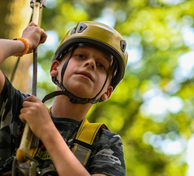 jeune garçon en train de faire de l'accrobranche lors de tourisme en bourgogne