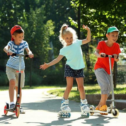trois enfants qui font de la trotinnette et du roller au camping avec activités en bourgogne