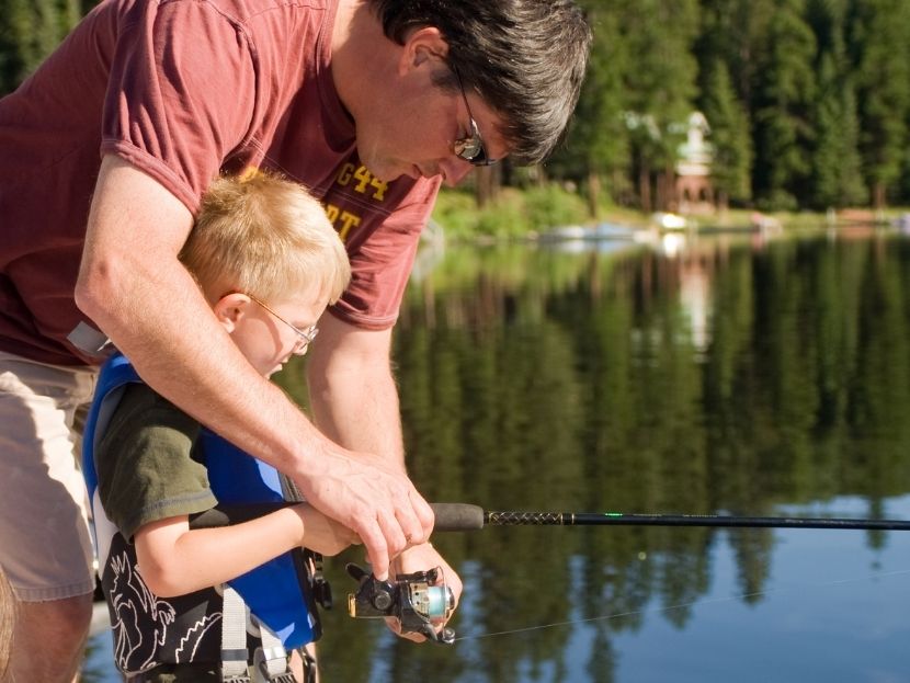 un papa et son enfant qui pechent ensemble au camping l'étang du merle en bourgogne