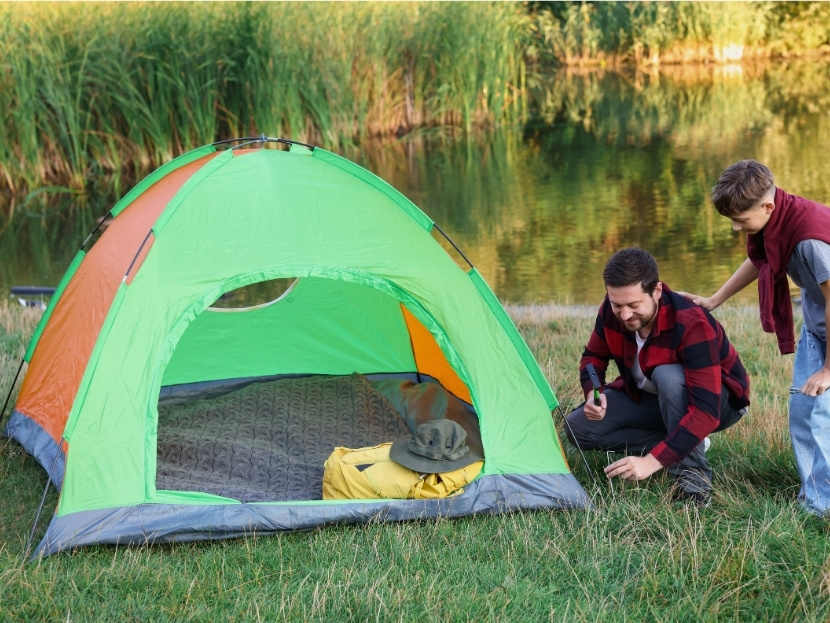 un pere et son fils qui plante une tente au camping avec emplacement en bourgogne