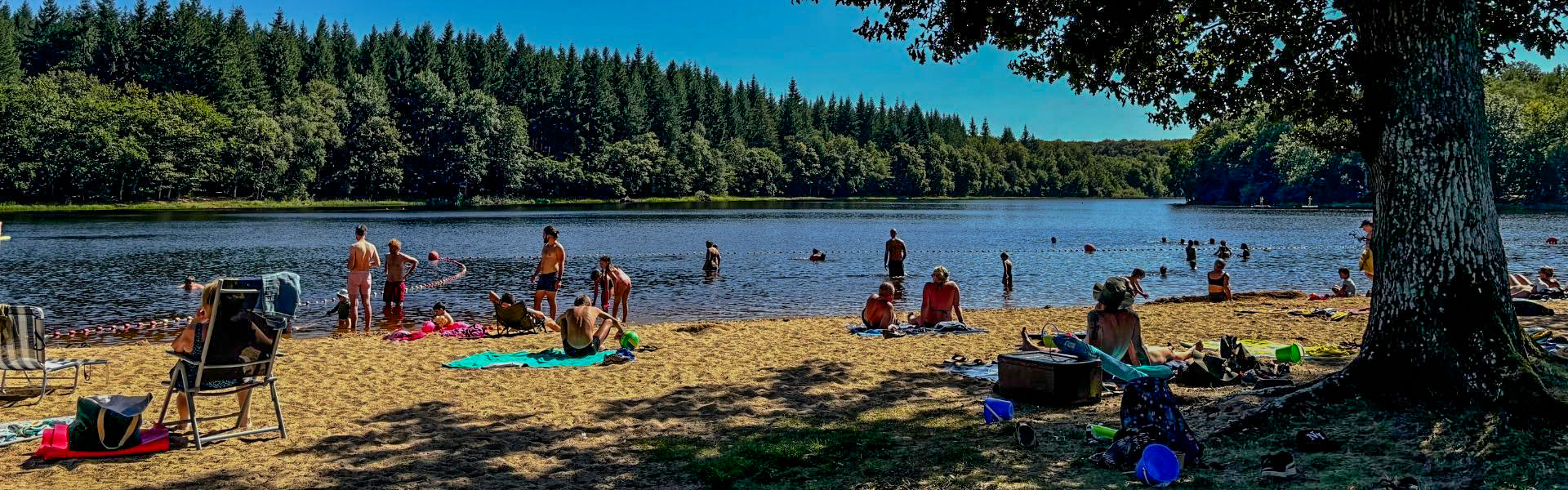vacanciers qui bronzent et jouent dans l'eau à la base de loisirs au camping pas cher en bourgogne
